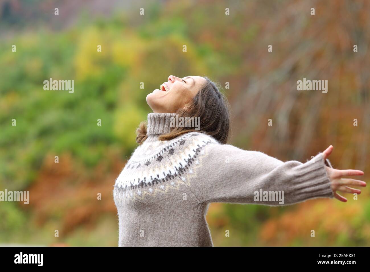 Middle age excited woman celebrating in the mountain Stock Photo