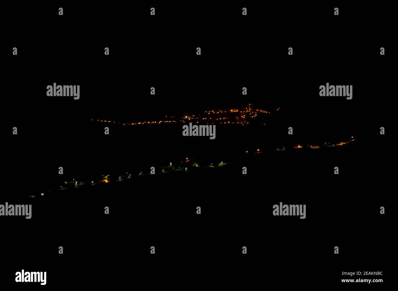 Village of El Toscon in the foreground and town of Artenara in the background at night. Stock Photo