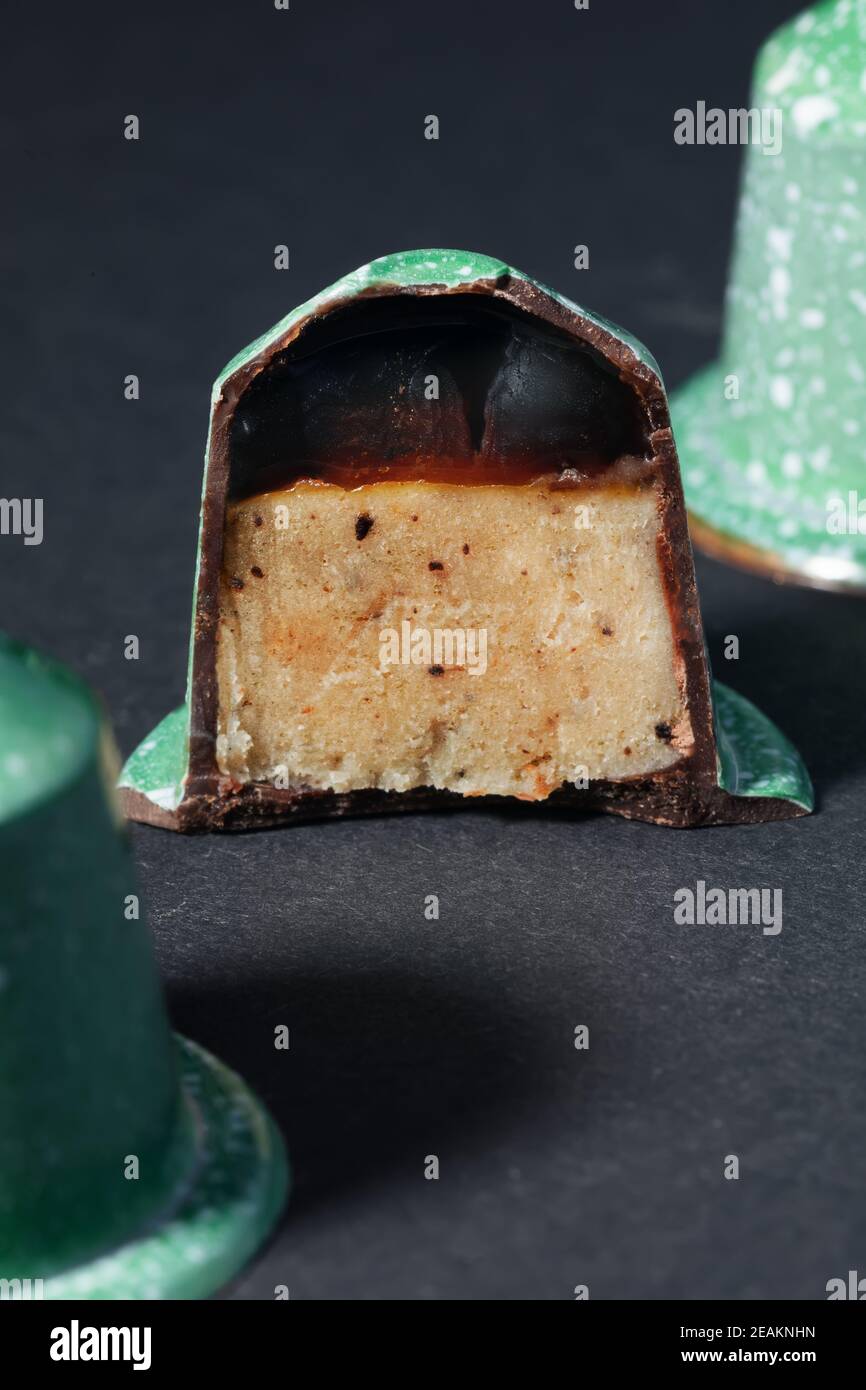 Chocolate candies in the shape of a coffee capsule with coffee reduction jelly and irish cream