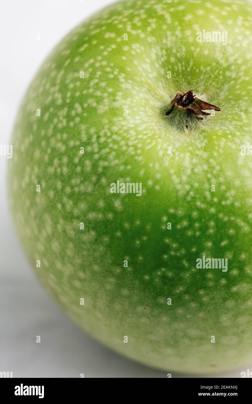 Green granny smith apple with white dots on the peel. Macro, selective