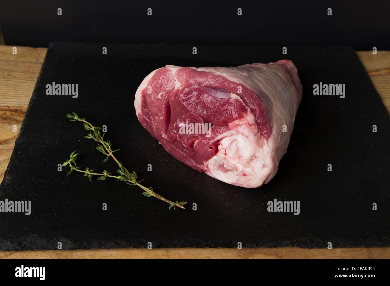 raw beef photographed on a wooden cutting board with a black background Stock Photo