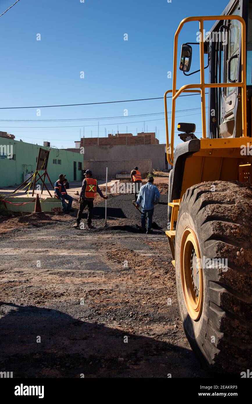 Workers spread asphalt on a road in San Carlos, Sonora, Mexico. Stock Photo