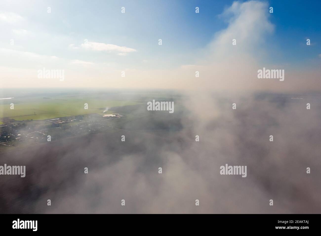 The smoke over the village. Clubs of smoke over the village houses and fields. Aerophotographing areas Stock Photo