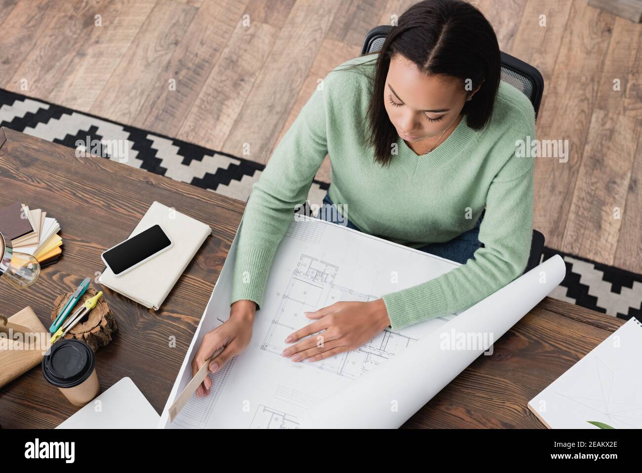 overhead view of african american architect holding ruler near ...