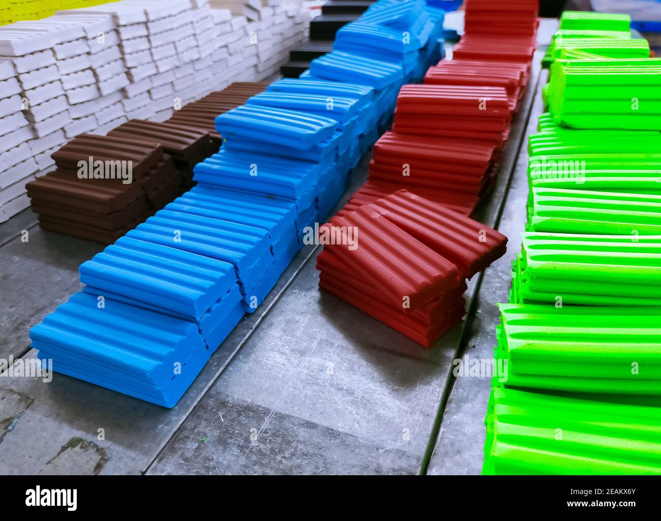 Heap of plasticine at production line in factory. Multi-colored modeling clay. Plasticine production industry. Modeling clay material for kids art education. Plasticine for preschool play dough. Stock Photo