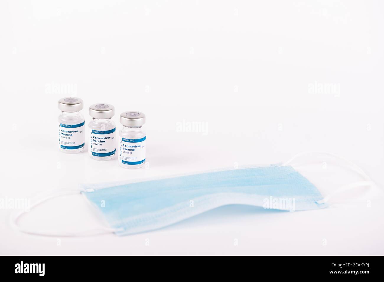 three Covid-19 vaccine vials with white background and a syringe to ...
