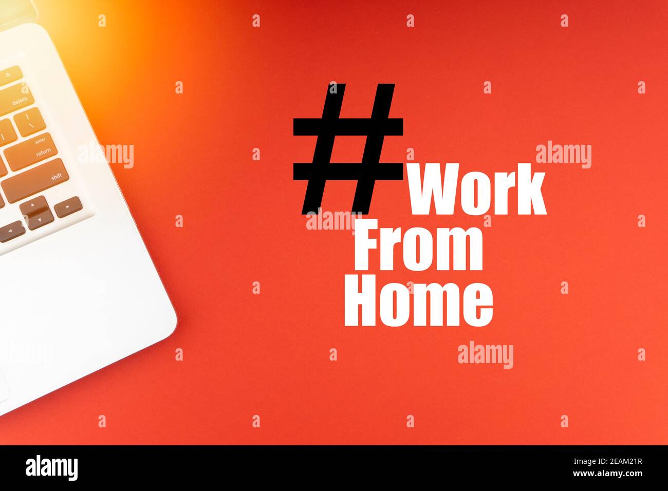 WORK FROM HOME text with laptop on red background Stock Photo