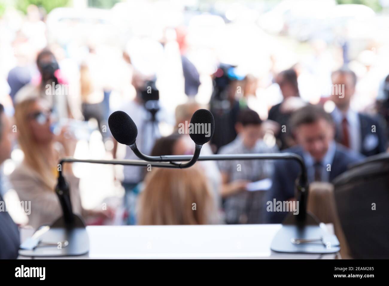 Microphone in focus at press or public event, blurred people in the  background Stock Photo - Alamy