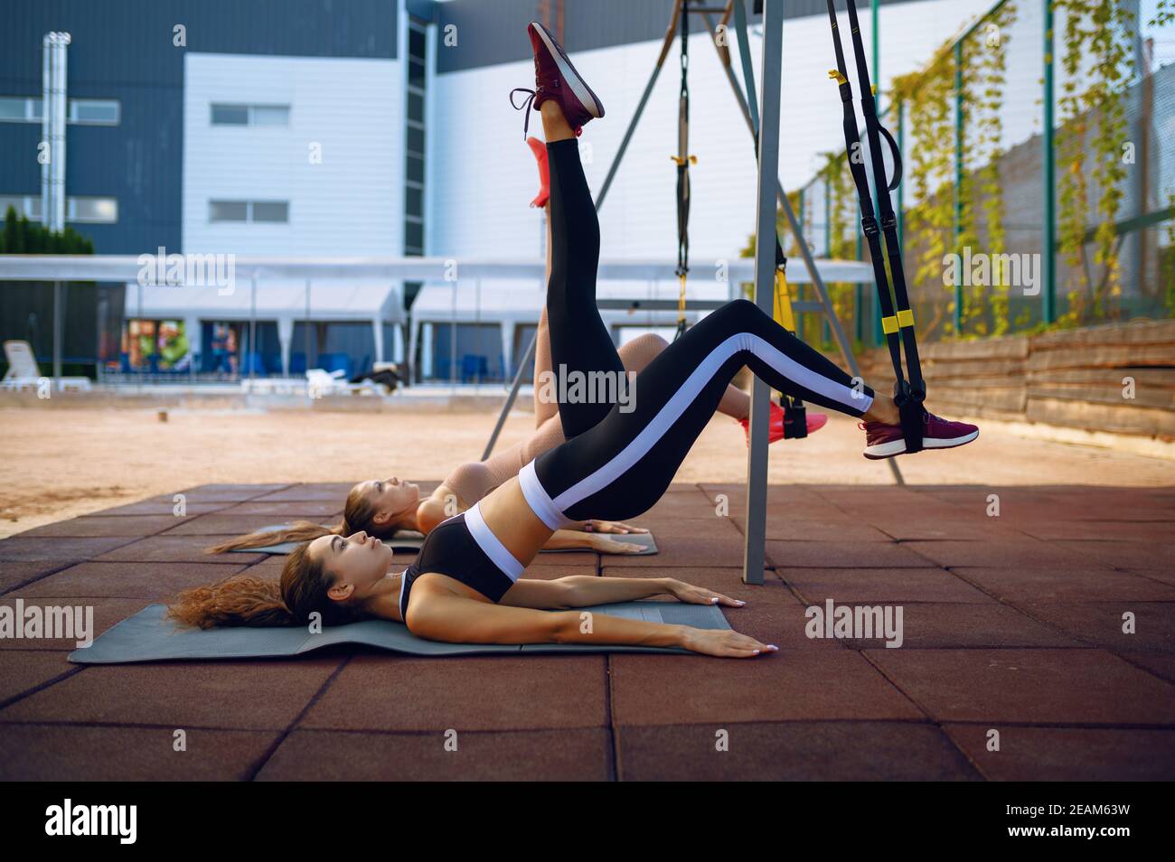 Woman doing stretching exercise with ropes outdoor Stock Photo