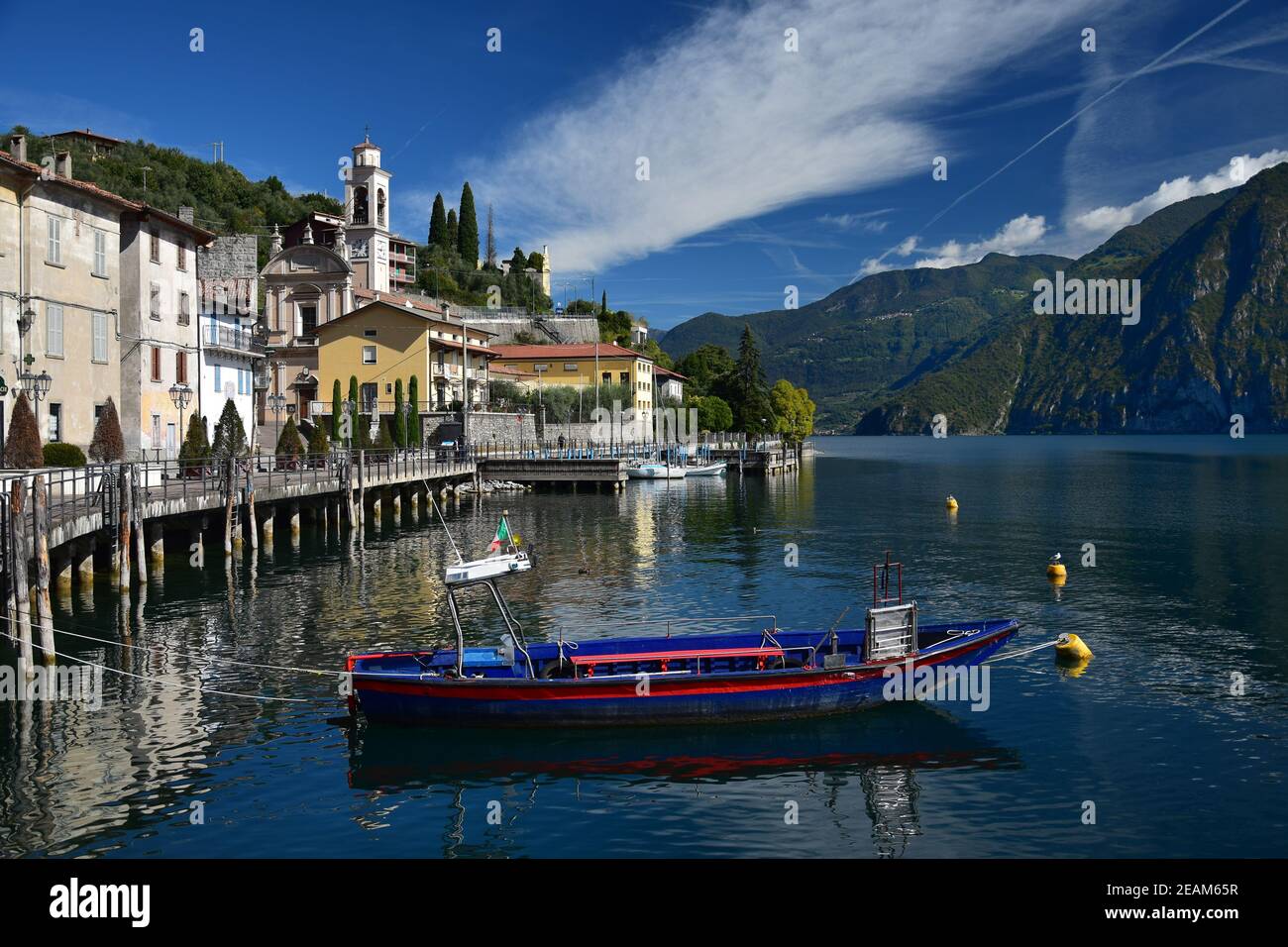 The small town Riva di Solto at Lake Iseo, Lombardy, Italy. A boat in front. Stock Photo