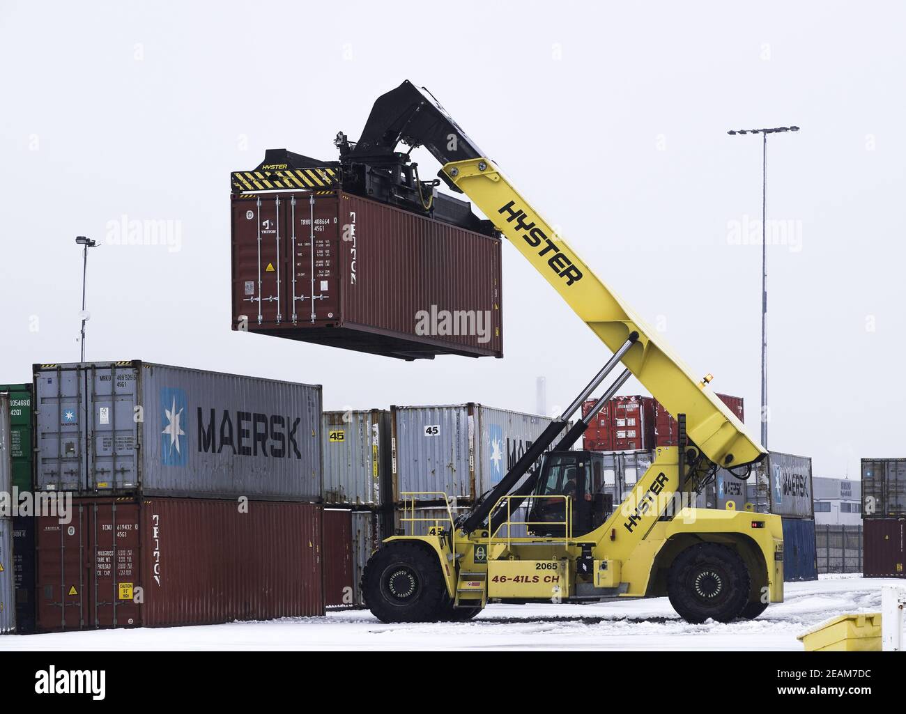 DONCASTER, UK - FEBRUARY 2, 2021.  A heavy lifting machine lifting a cargo box or shipping container in a rail terminal or yard, Stock Photo