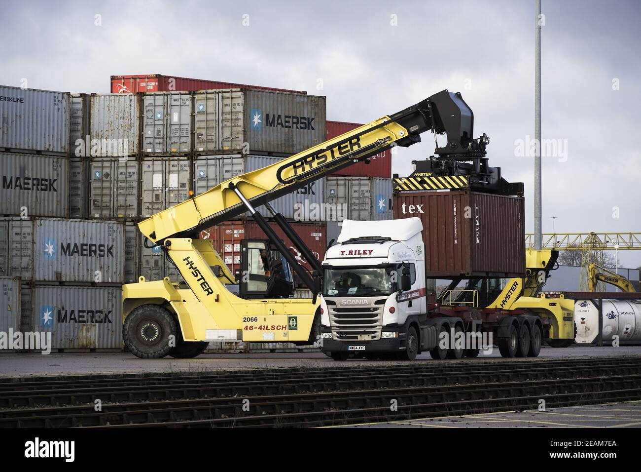 DONCASTER RAILPORT, DONCASTER, UK - JANUARY 29, 2021.  A heavy lifting machine loading a shipping container onto a road vehicle for onward transportat Stock Photo