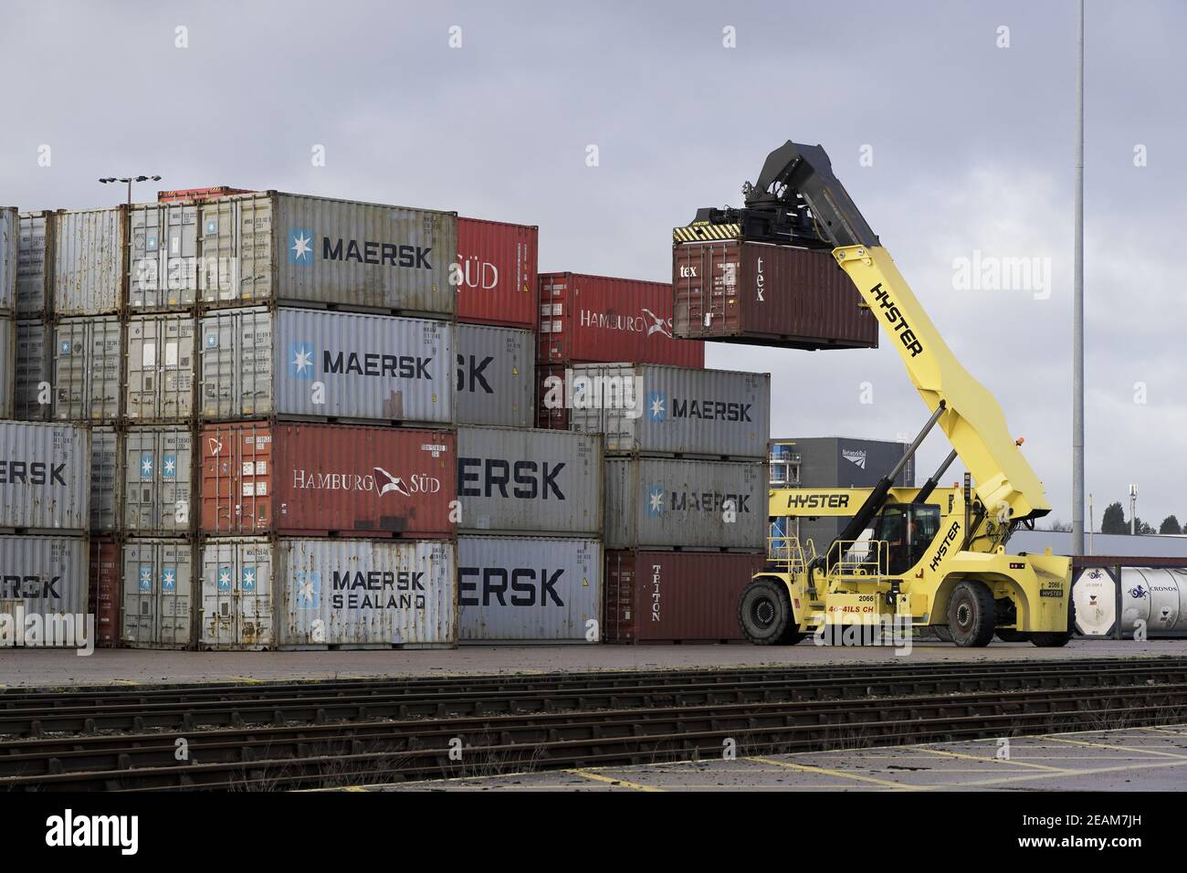 DONCASTER RAILPORT, DONCASTER, UK - JANUARY 29, 2021.  A heavy lifting machine stacking a shipping or cargo container for export and import to the UK Stock Photo