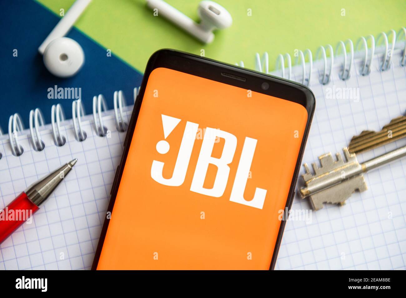 Poland. 9th Feb, 2021. In this photo illustration, a JBL logo seen  displayed on a smartphone with a pen, key, book and headsets in the  background. Credit: Mateusz Slodkowski/SOPA Images/ZUMA Wire/Alamy Live
