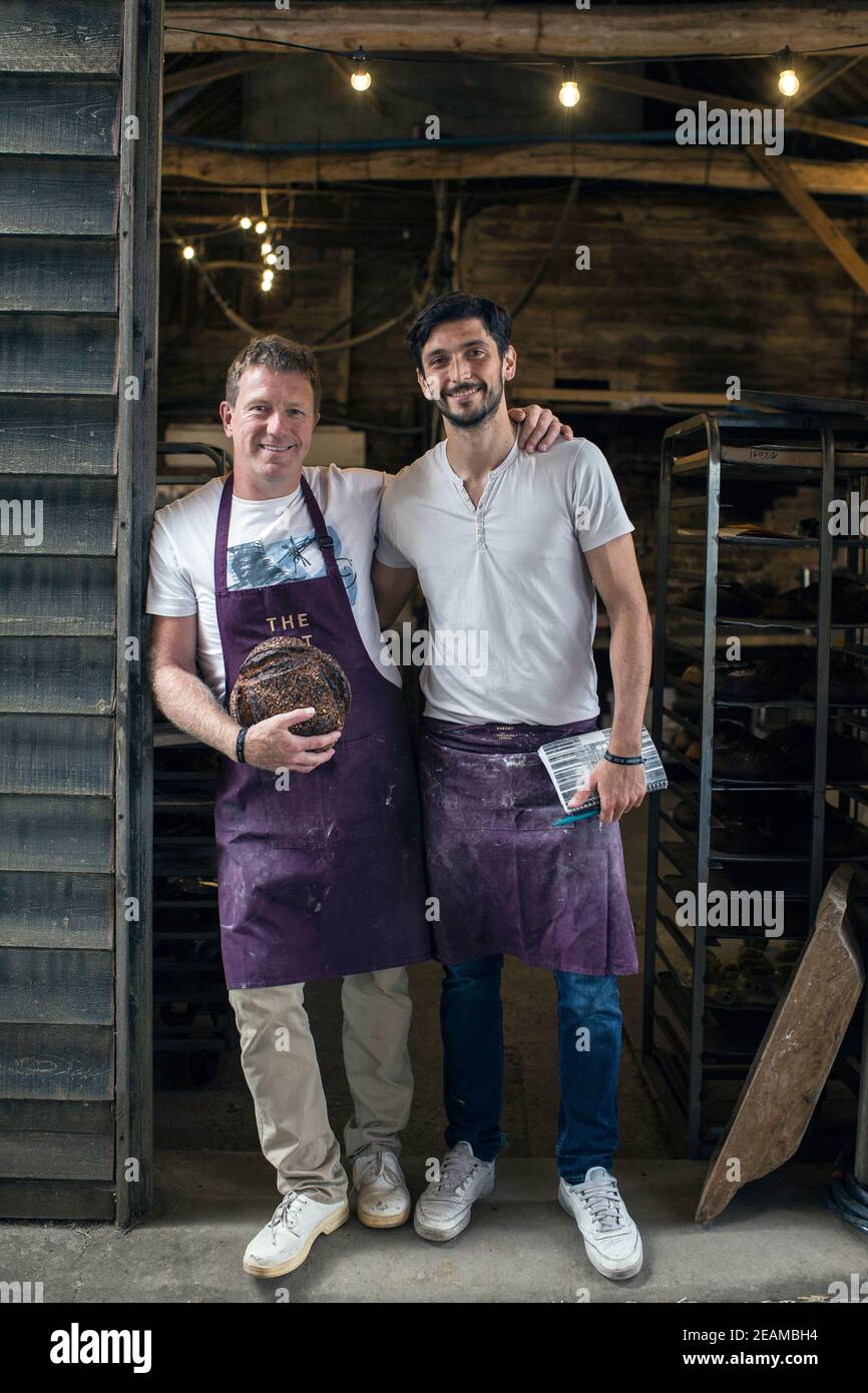 GREAT BRITAIN / England / Hertfordshire / Bakers holding freshly baked loaves of bread. Stock Photo