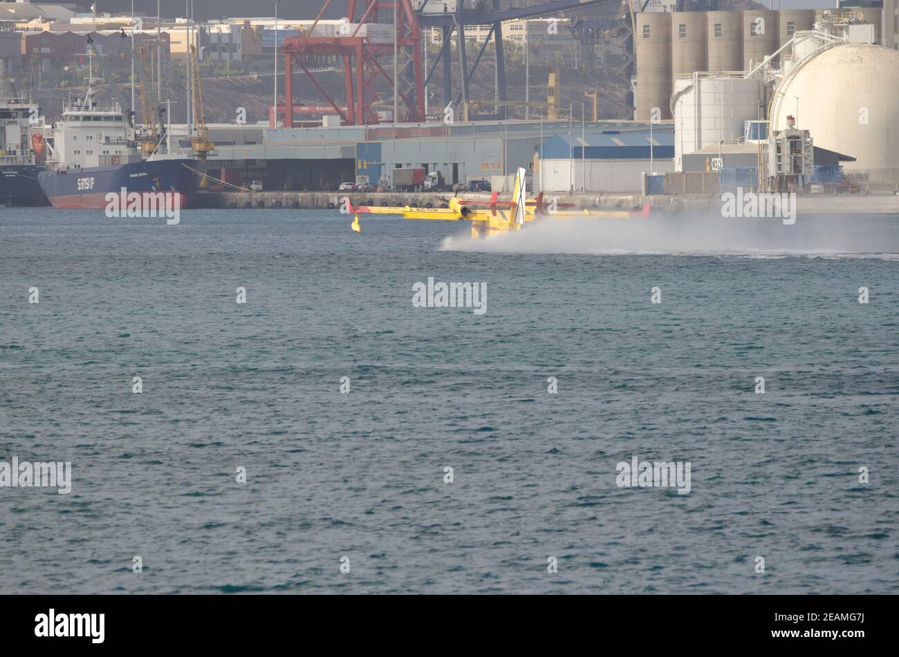 Fire-fighting plane collecting sea water to extinguish a forest fire. Stock Photo