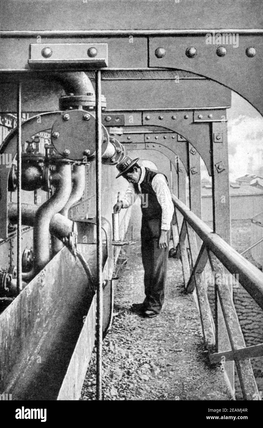An early 20th century print of Chilean worker running off Sodium nitrate solution from the tank room where caliche mineral deposits were boiled as part of the sodium nitrate mining industry in the Atacama desert Chile South America circa 1920 Stock Photo
