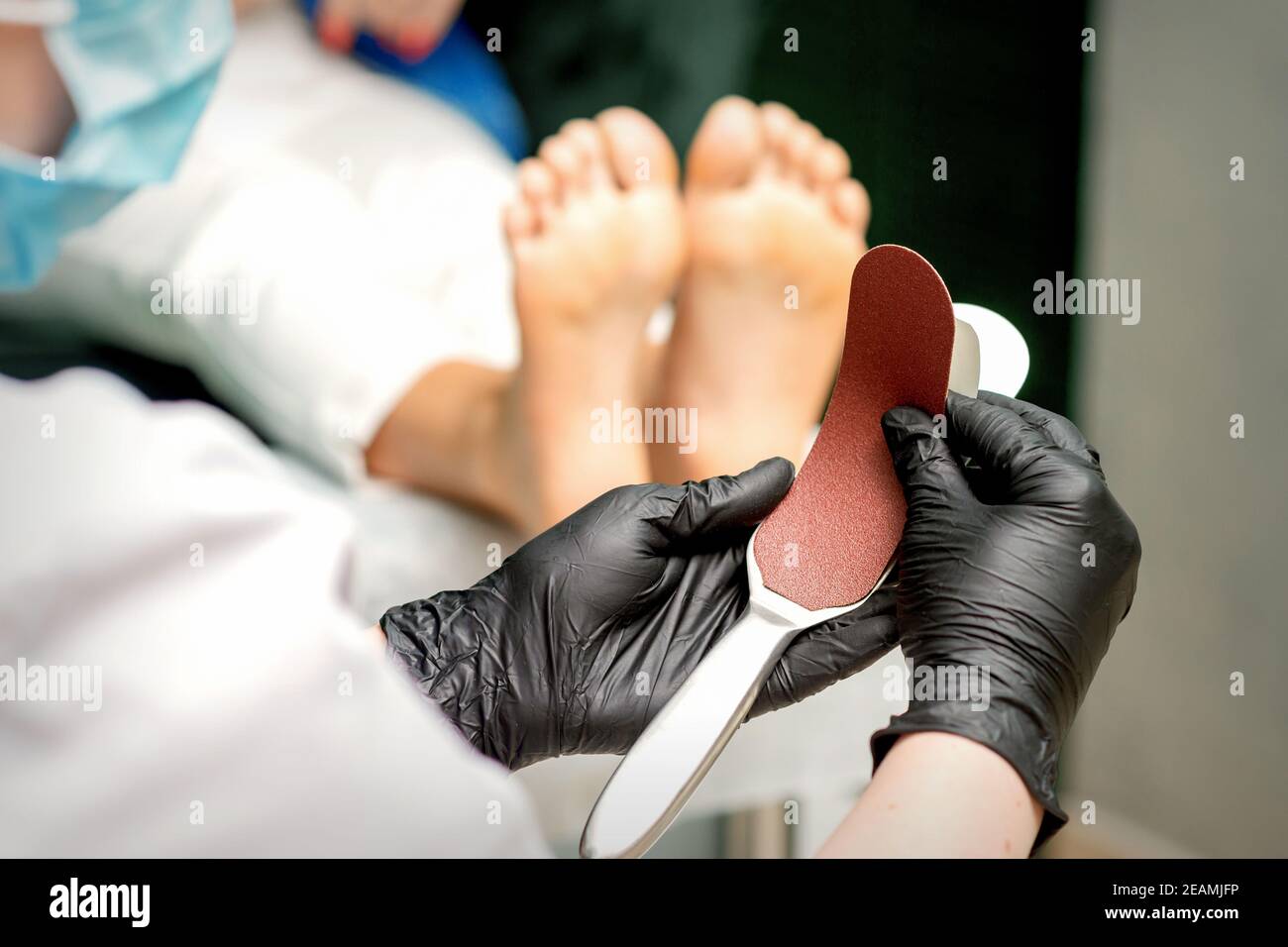 The pedicurist put on a new heel file on the metal handle before the