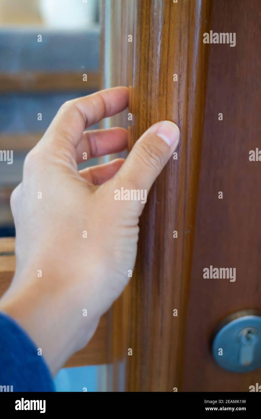 Hand on opening a wooden door Stock Photo