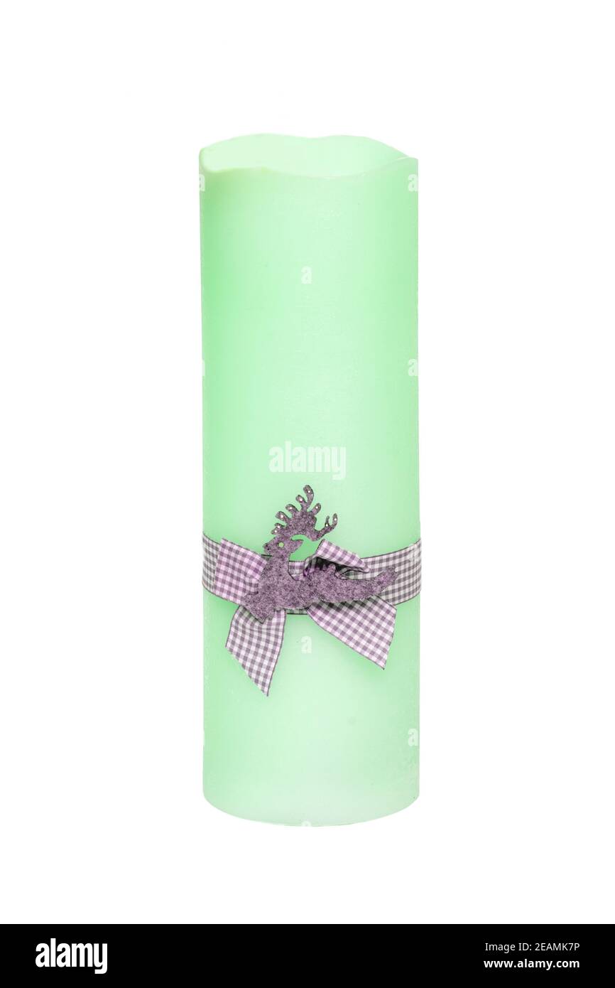 Christmas candle isolated. Closeup of a light green xmas candle with a light gray ribbon bow isolated on a white background. Beautiful xmas design element. Macro. Stock Photo