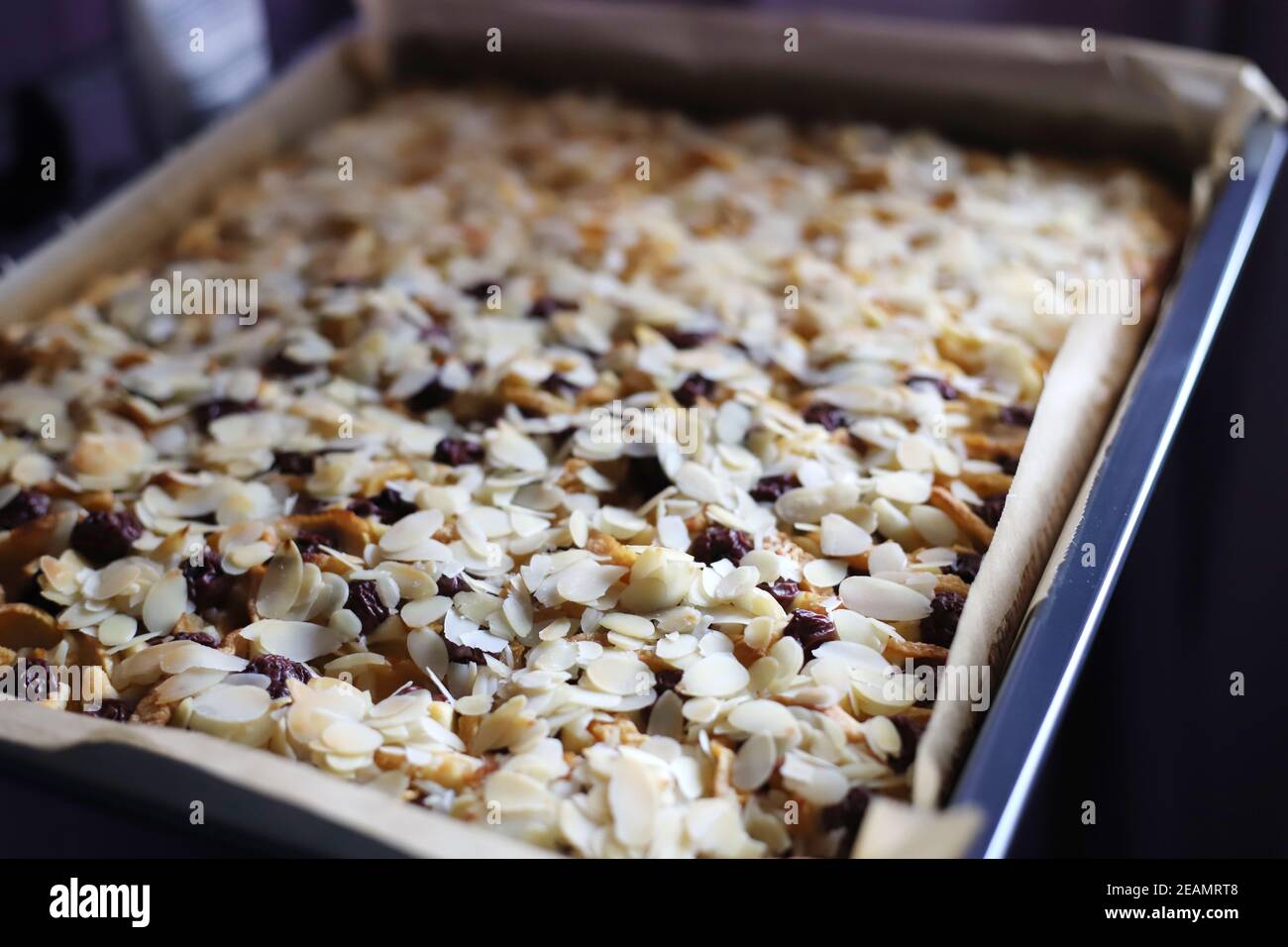Blechkuchen mit Ã„pfeln, Kirschen und gehobelten Mandeln Stock Photo