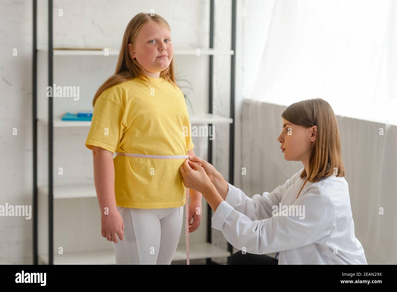 Doctor measuring girl's waist, checking the results of a diet Stock Photo