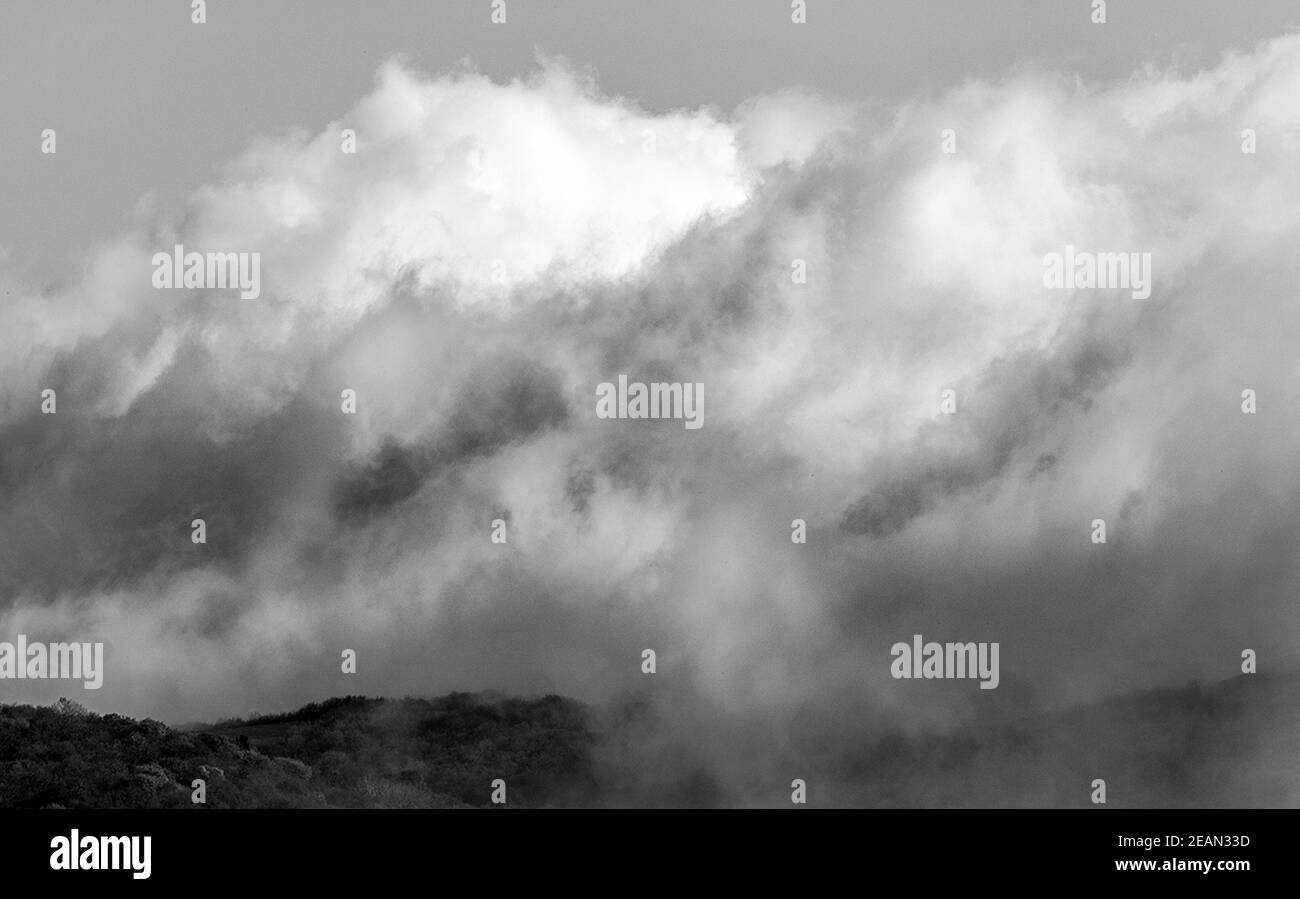 Low clouds over valley, view from the mountains. Low clouds. Stock Photo