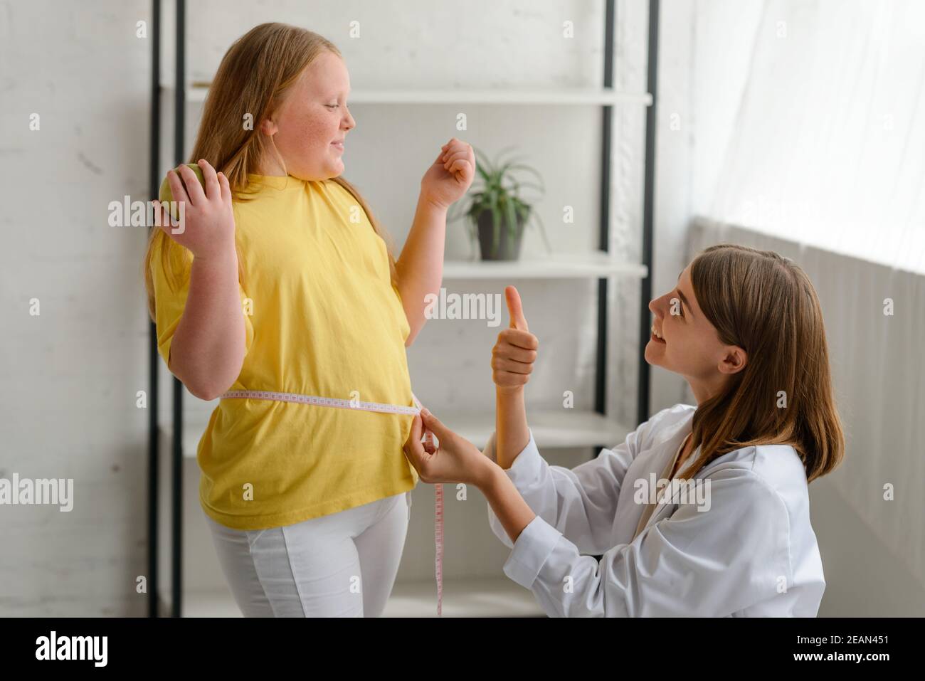 Nutritionist congratulates her young patient with a good result Stock Photo