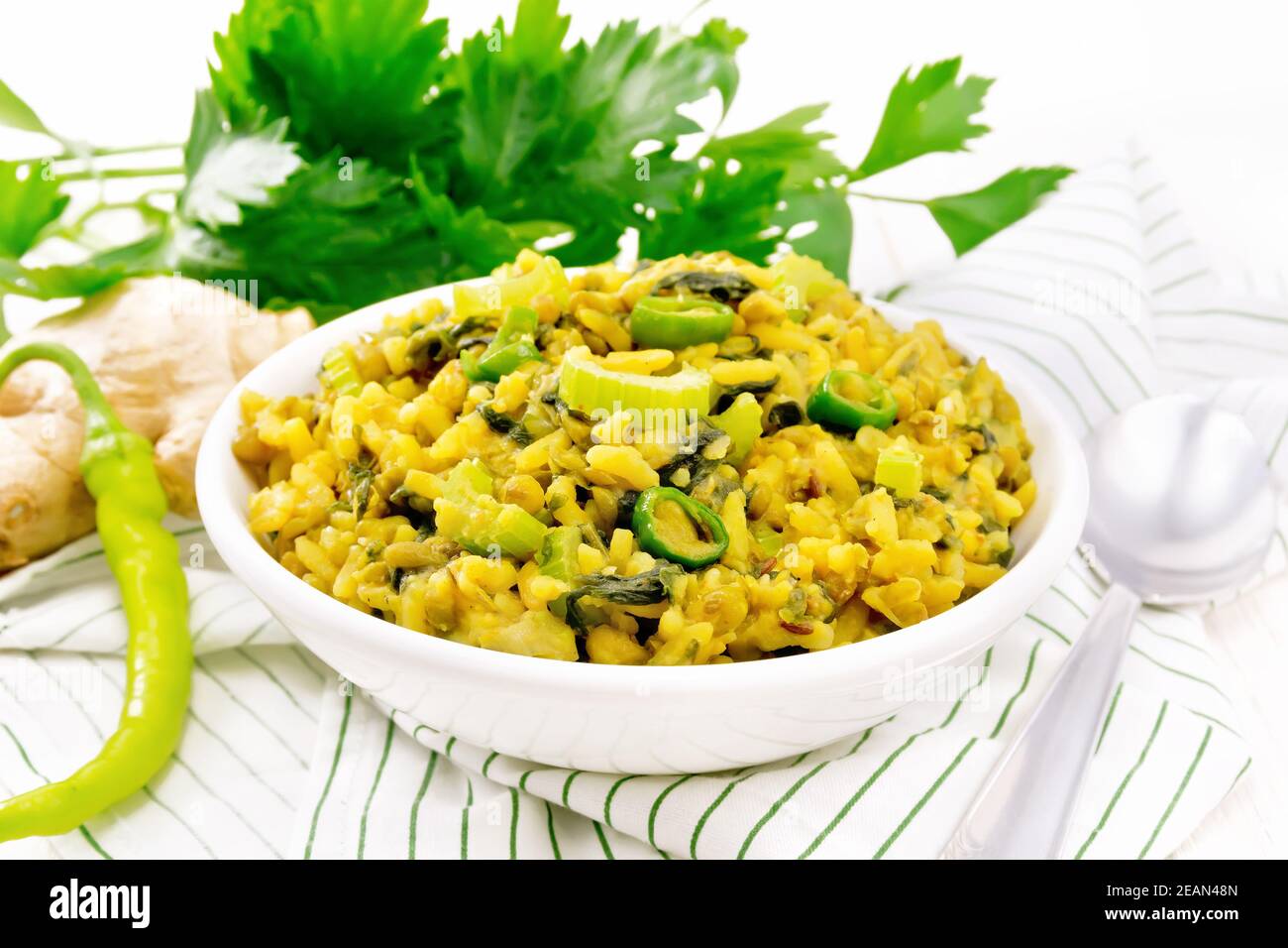 Kitchari with celery in bowl on light board Stock Photo