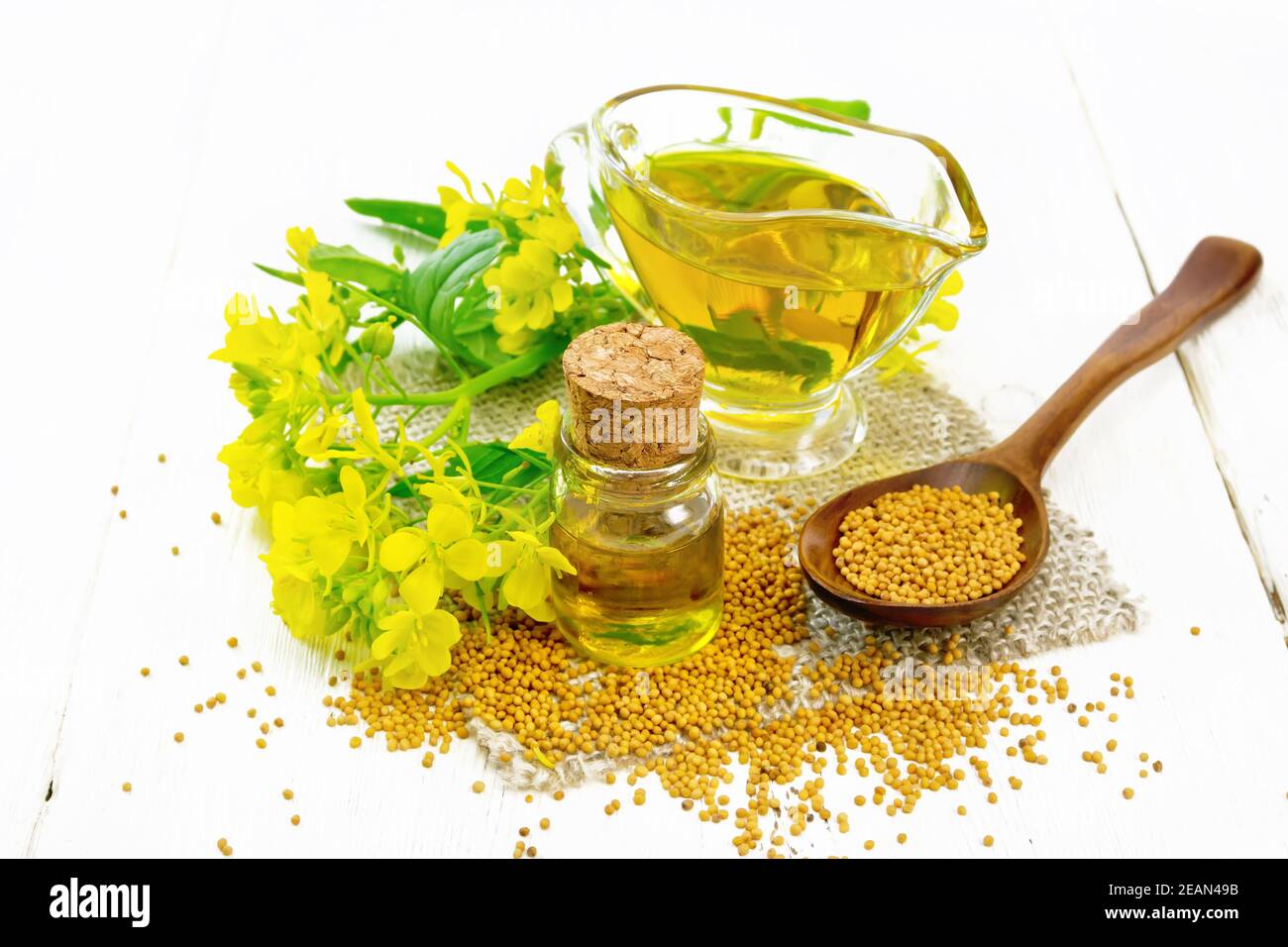 Oil mustard in jars and gravy boat on white board Stock Photo