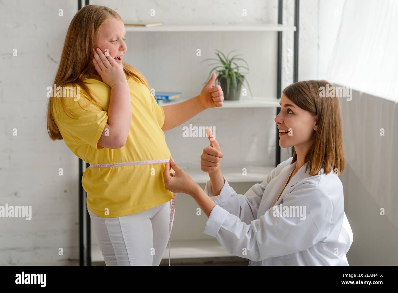 Happy fat girl and nutritionist rejoices about good result of being on a diet Stock Photo