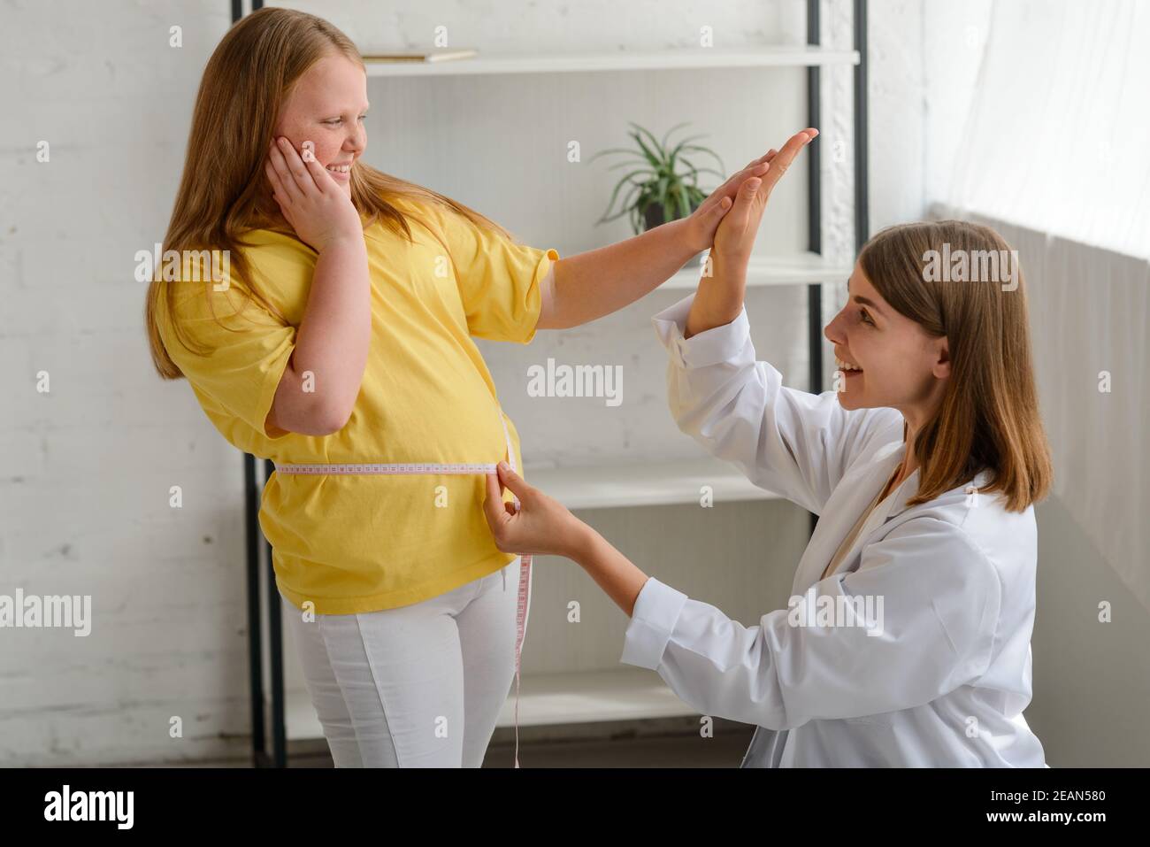 Nutritionist and fat girl celebrating first good results of a diet Stock Photo