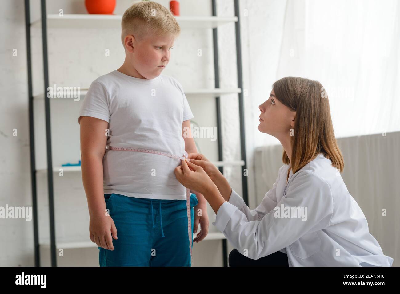 Little chubby boy being measured by a friendly doctor Stock Photo