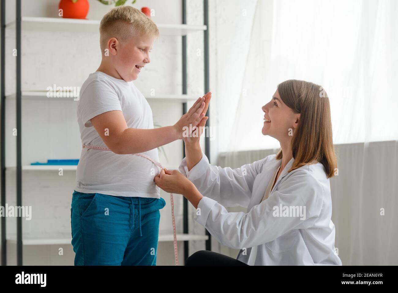 Doctor congratulates an obese boy with first good results Stock Photo
