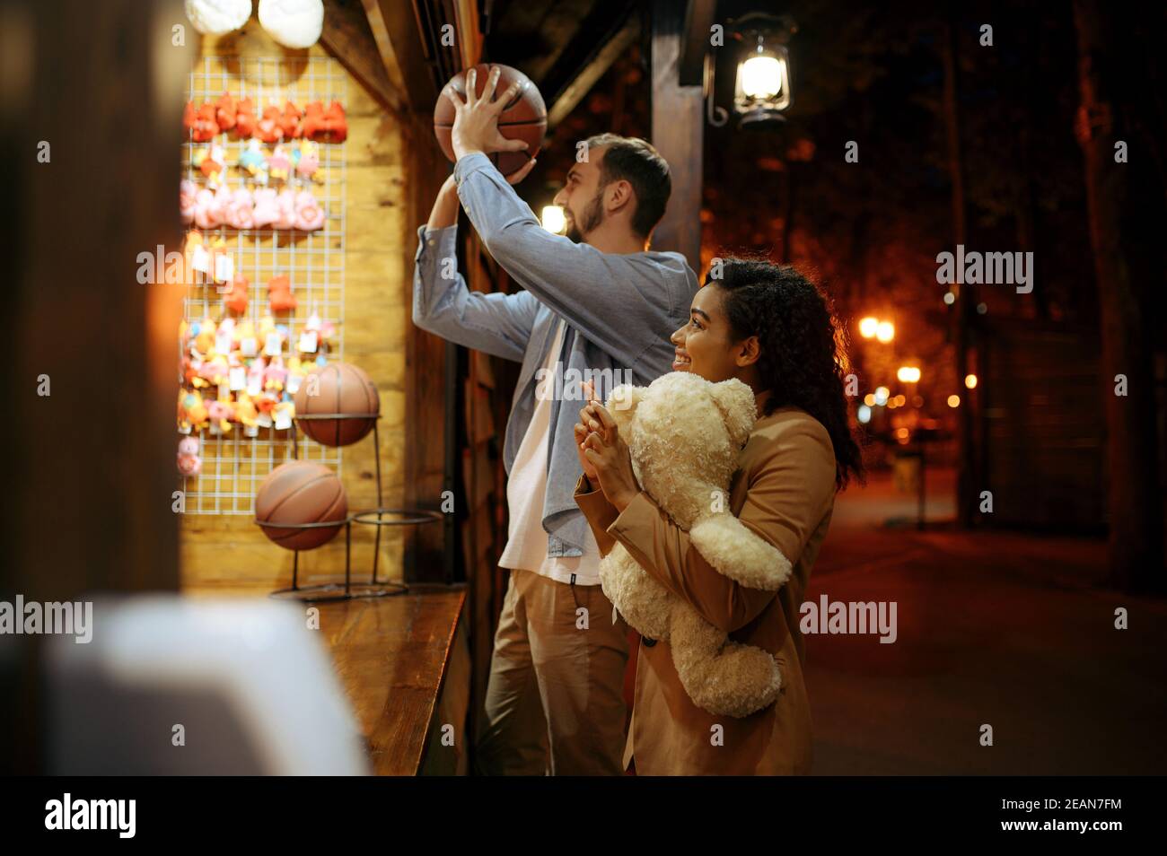 Couple play in shooting gallery, amusement park Stock Photo