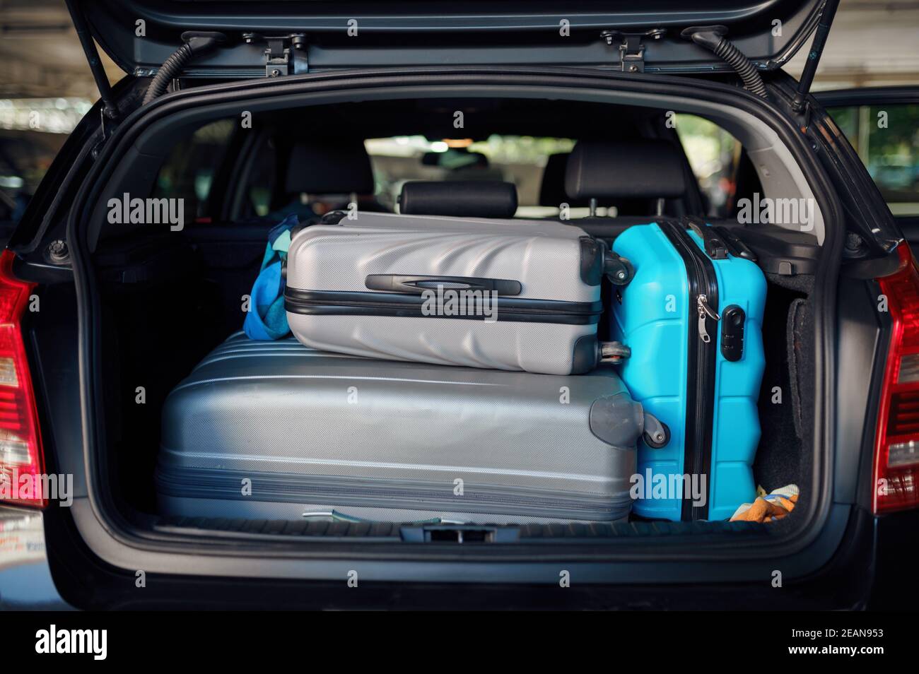 Suitcases in opened car trunk on parking, nobody Stock Photo