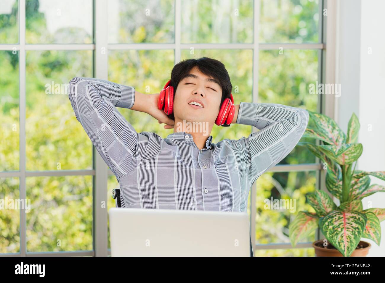 business man smile listening music in red headphone at home office Stock Photo