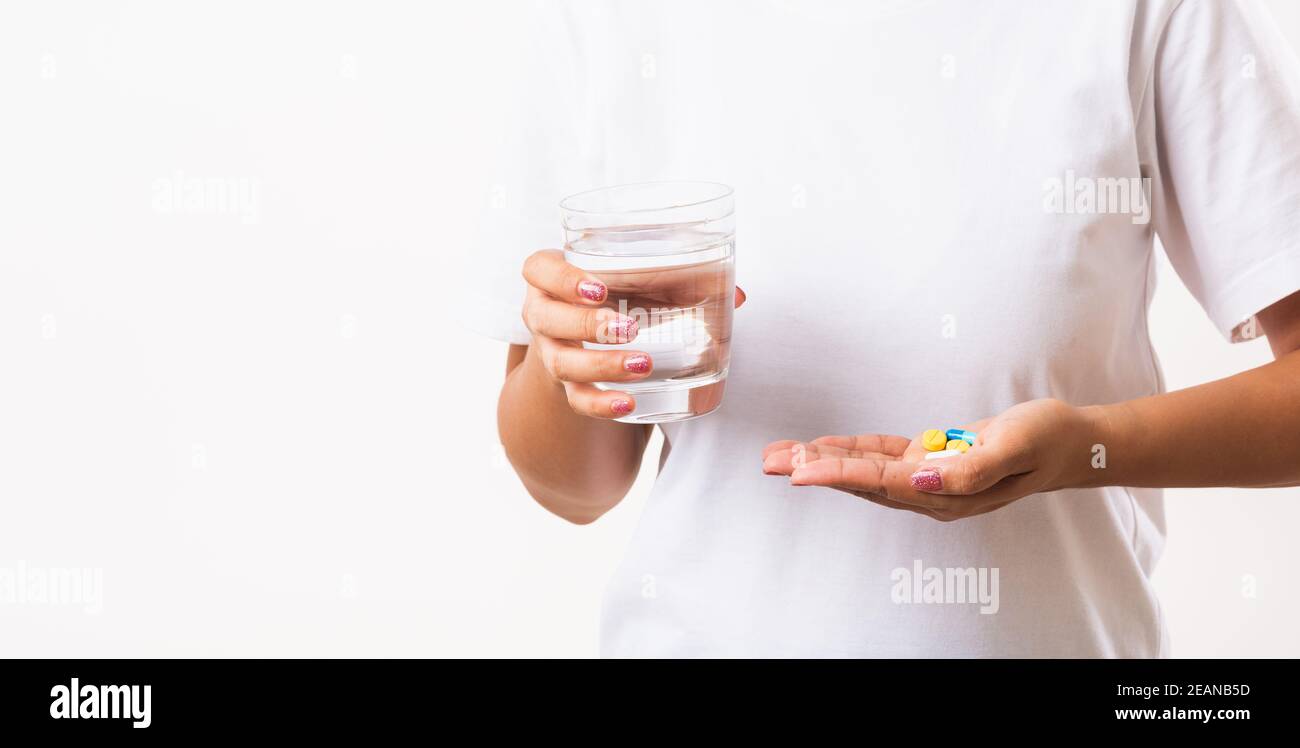 Woman hold pill drugs in hand ready take medicines with a glass of