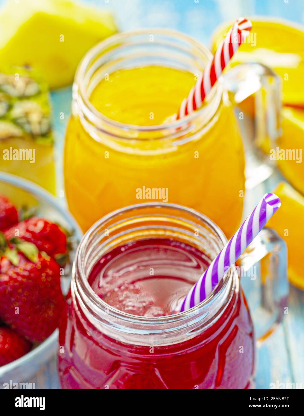 Orange and strawberry juice in glass on old wooden blue table Stock Photo