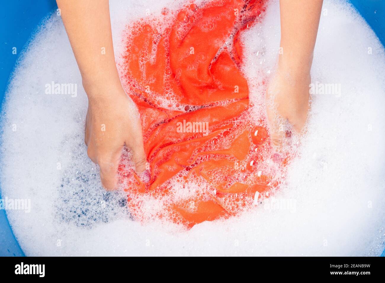 Woman use hands washing color clothes in basin Stock Photo