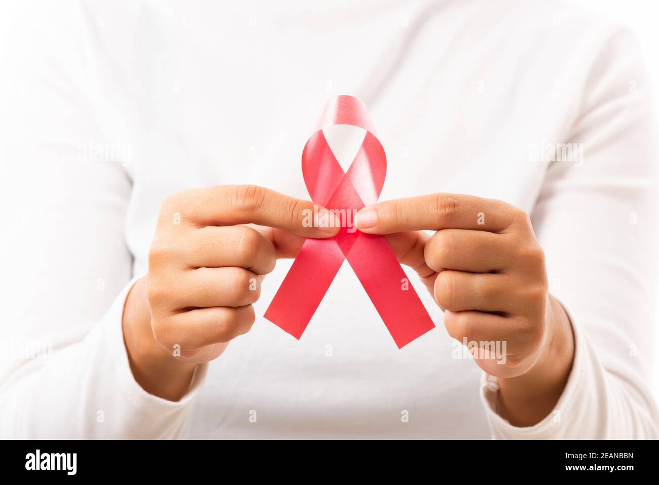 Female holding HIV AIDS awareness red ribbon Stock Photo - Alamy