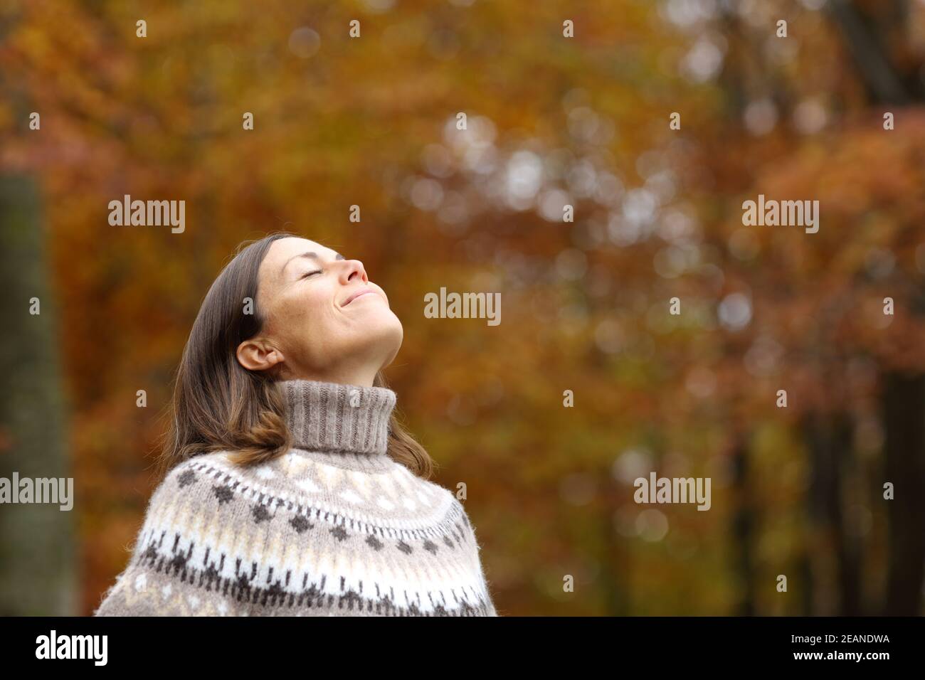 Middle age woman breathing deep fresh air in autumn Stock Photo