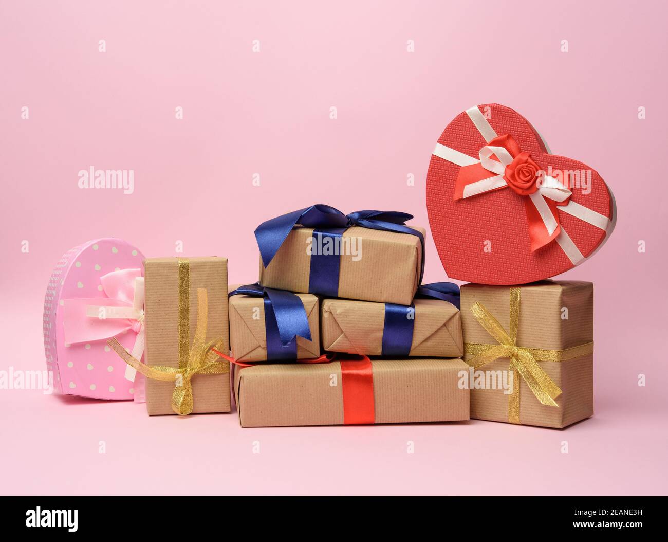 stack of gifts wrapped in brown kraft paper and tied with silk ribbon