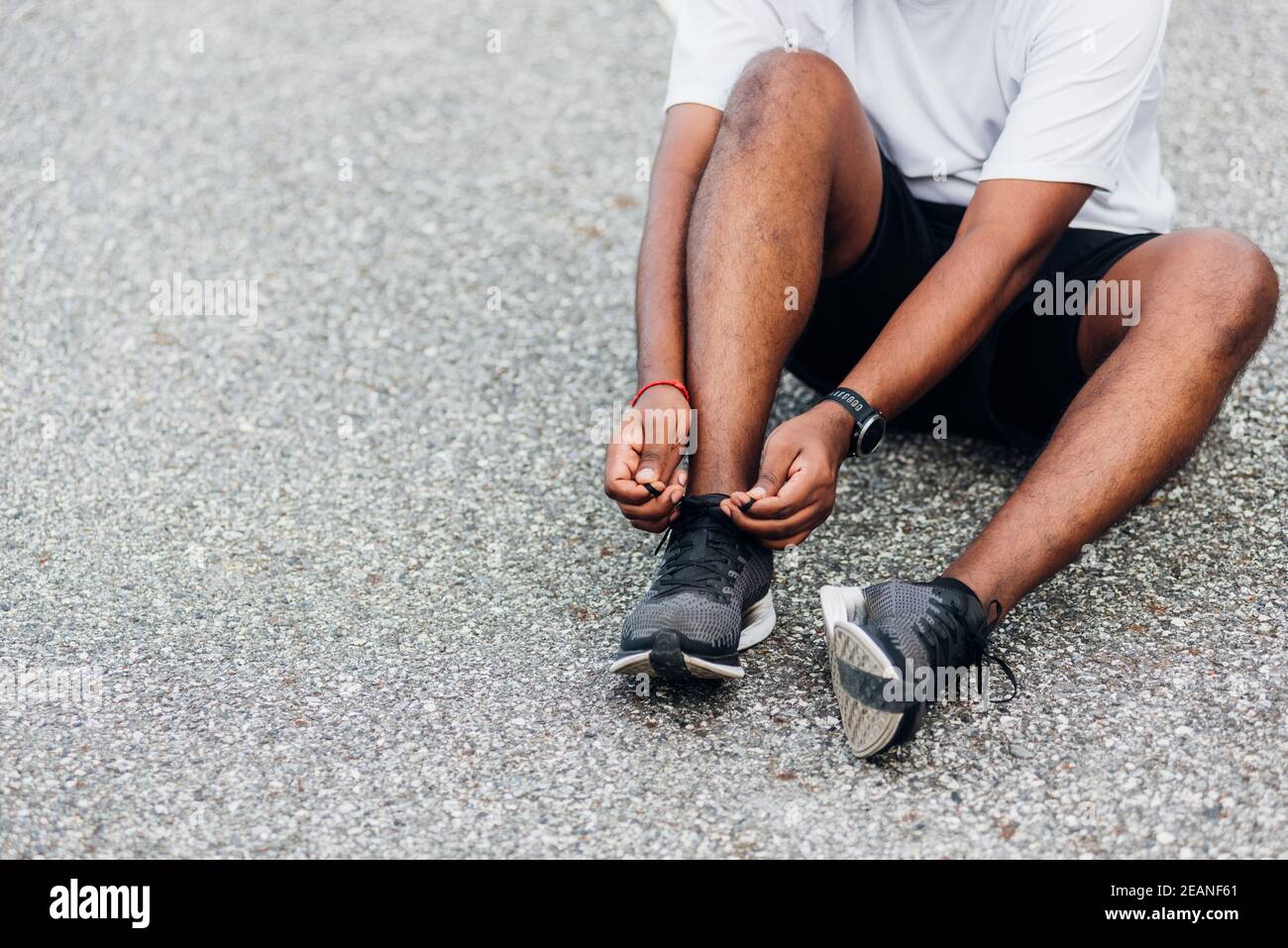 sport runner black man wear watch sitting he trying shoelace running shoes Stock Photo