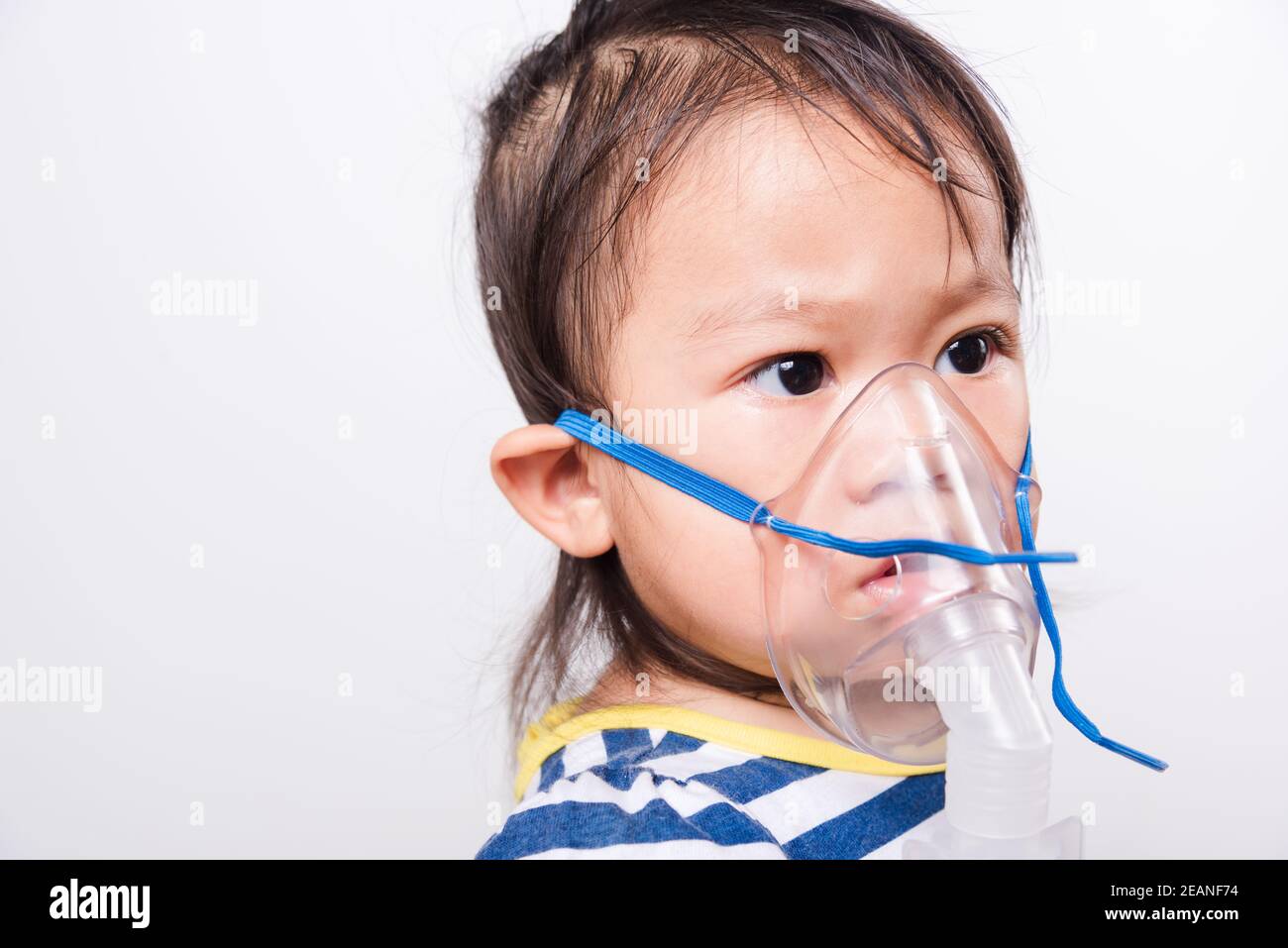 Closeup Asian face, Little baby girl sick her using steam inhaler nebulizer mask inhalation oneself Stock Photo
