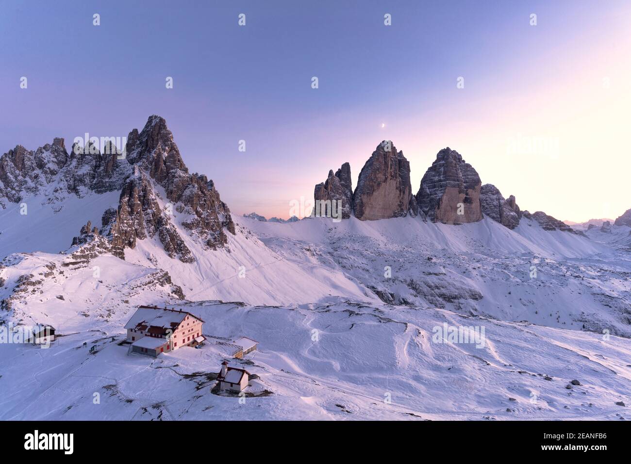 Sunset over Monte Paterno, Tre Cime di Lavaredo and Locatelli hut covered with snow, Sesto Dolomites, South Tyrol, Italy, Europe Stock Photo