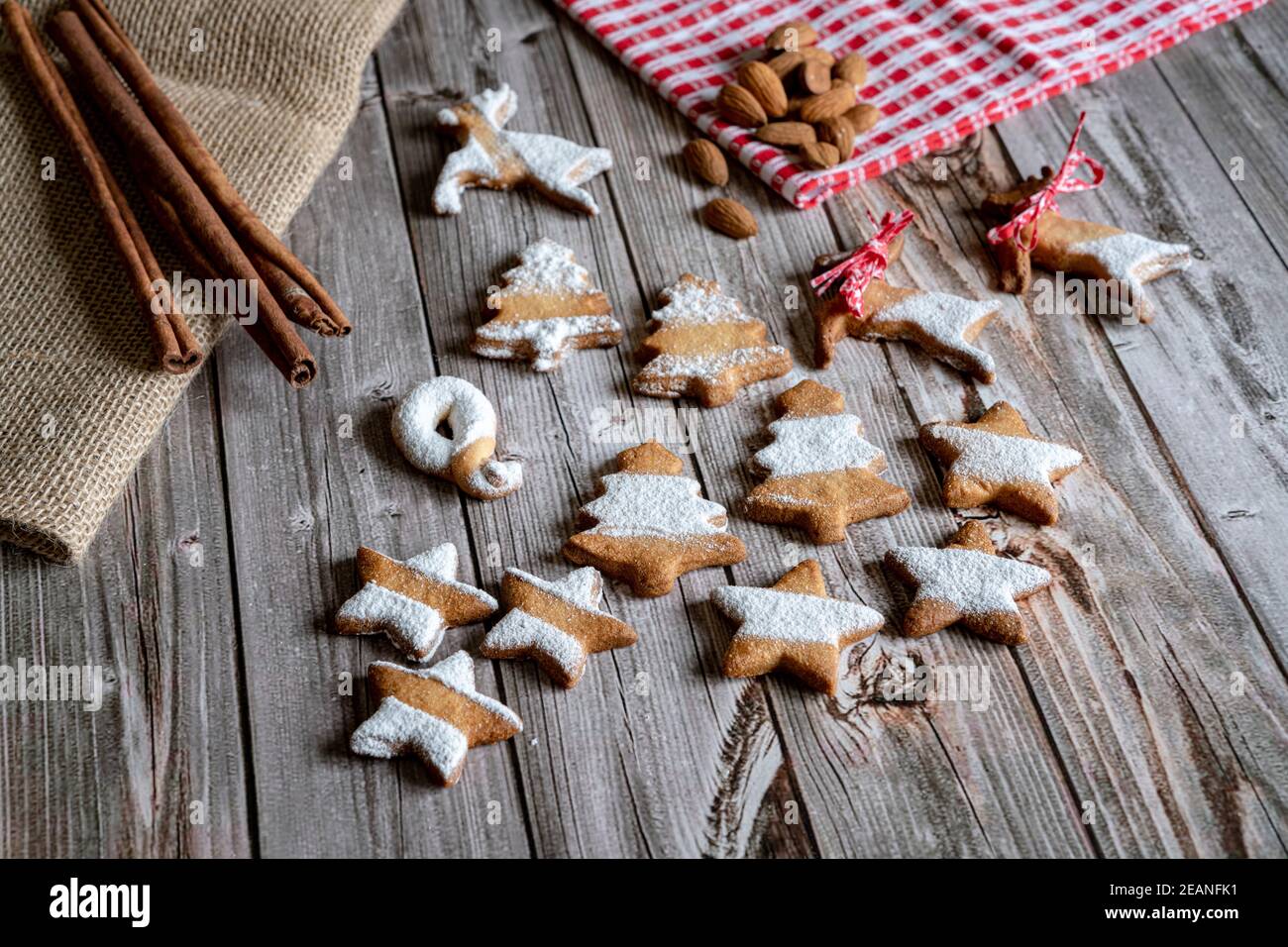Gingerbread and butter cookies in shape of Christmas tree and stars with almond and cinnamon on wood table background, Italy, Europe Stock Photo