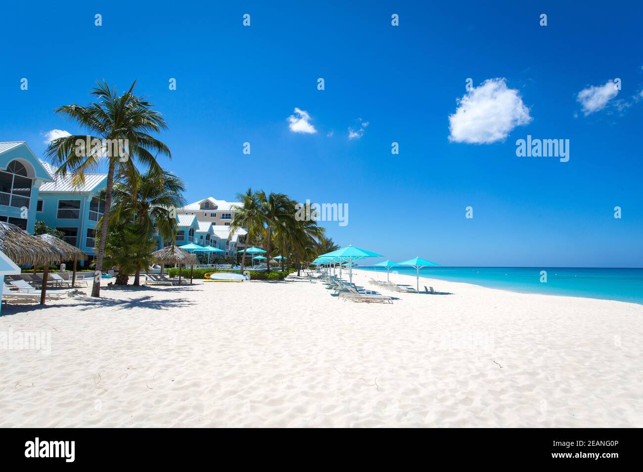 Grand Cayman Beach Deck Chairs Blue Umbrellas On Water's Edge, Cayman