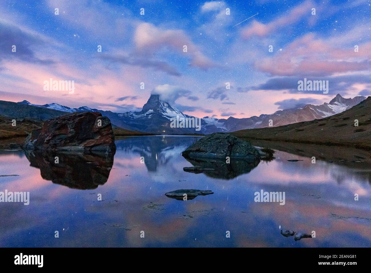 Glowing stars over Matterhorn mirrored in lake Stellisee at dusk, Zermatt, Valais canton, Switzerland, Europe Stock Photo