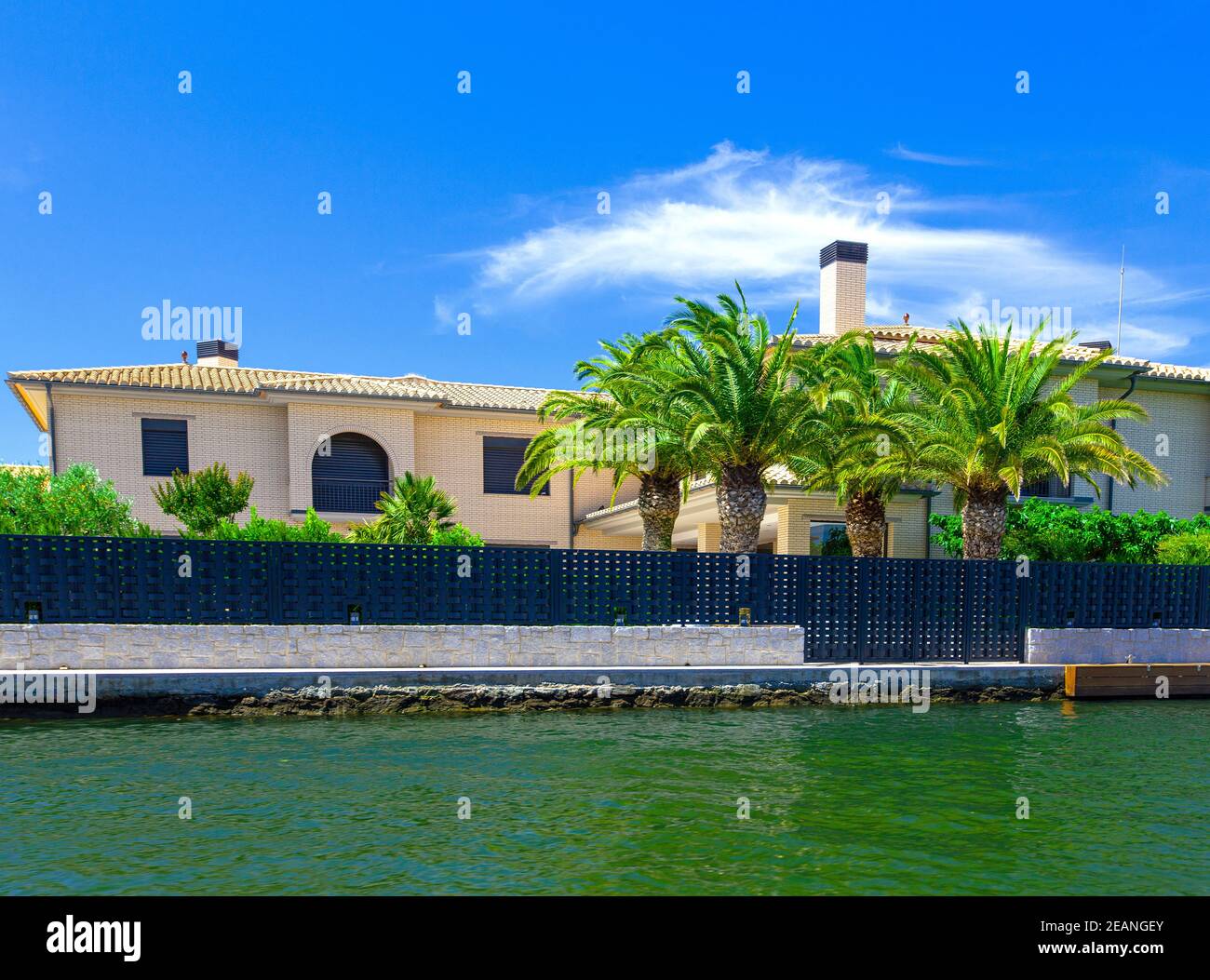 house with palm by the water at the resort in Spain Stock Photo